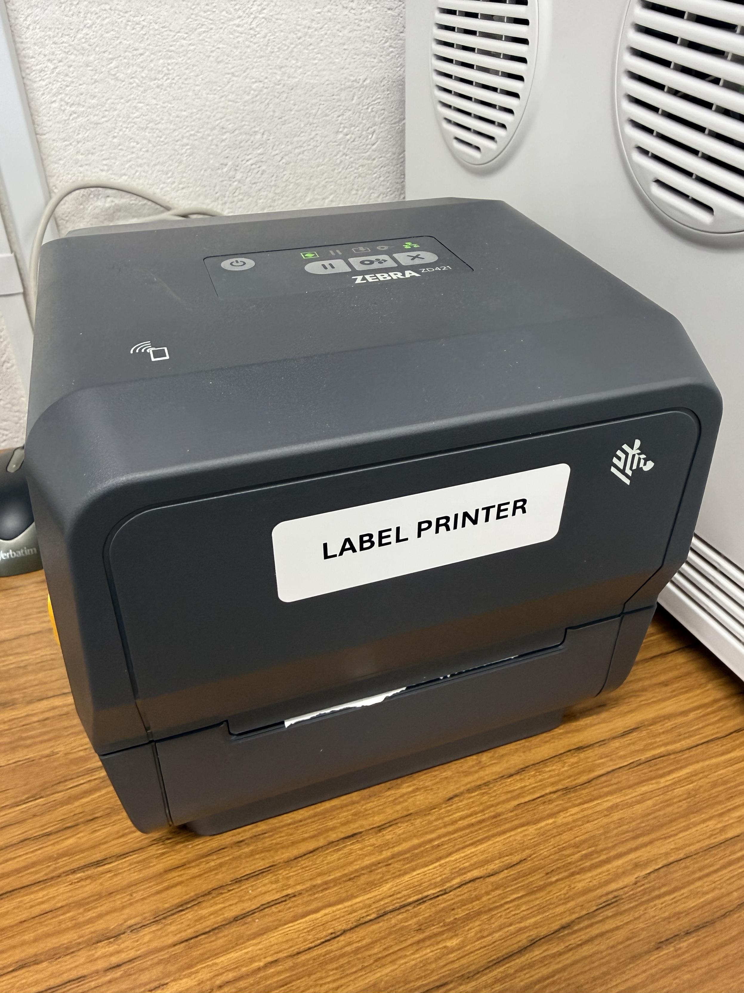 A Zebra label printer with a sticker on it that says “label printer”.