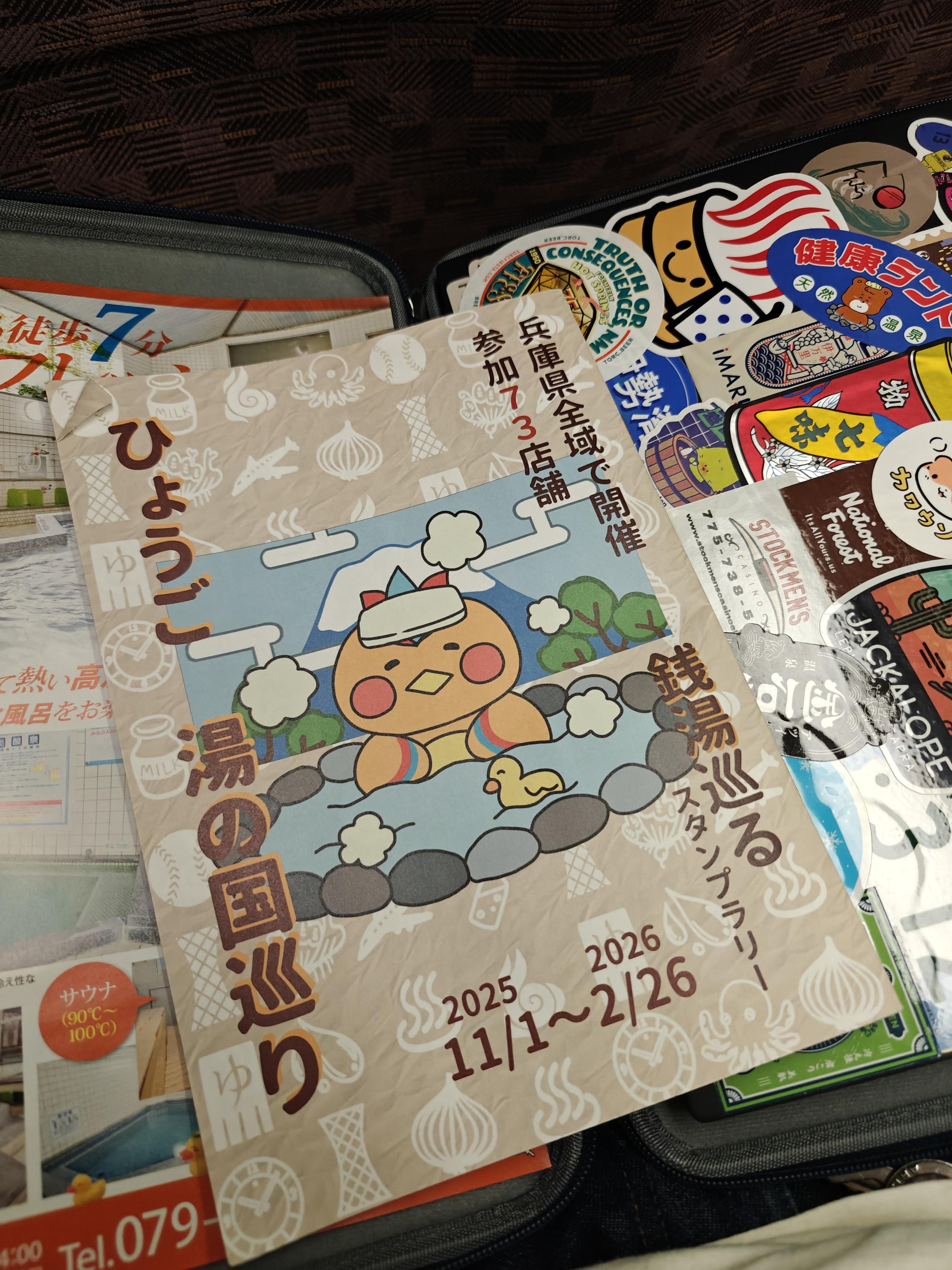 A pamphlet/stamp book for the "Hyogo Yu no Kuni Meguri". There is an illustration of a phoenix-like bird sitting in a rock lined outdoor bath with a towel on its head. All of the text is in Japanese.